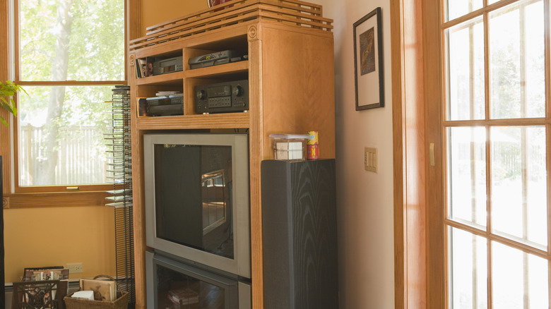 A large retro entertainment center made of wood in a living room.