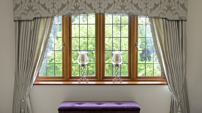 A bedroom window with heavy curtains and a valance.