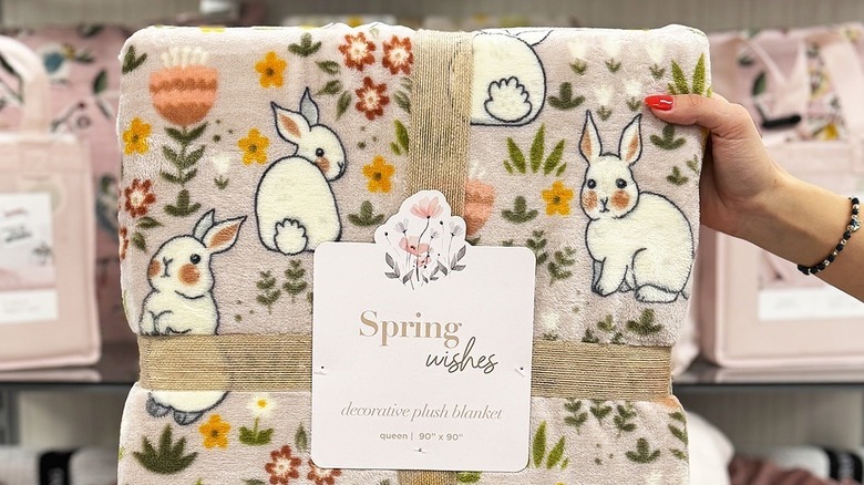Person holding a bunny-themed blanket in TJ Maxx
