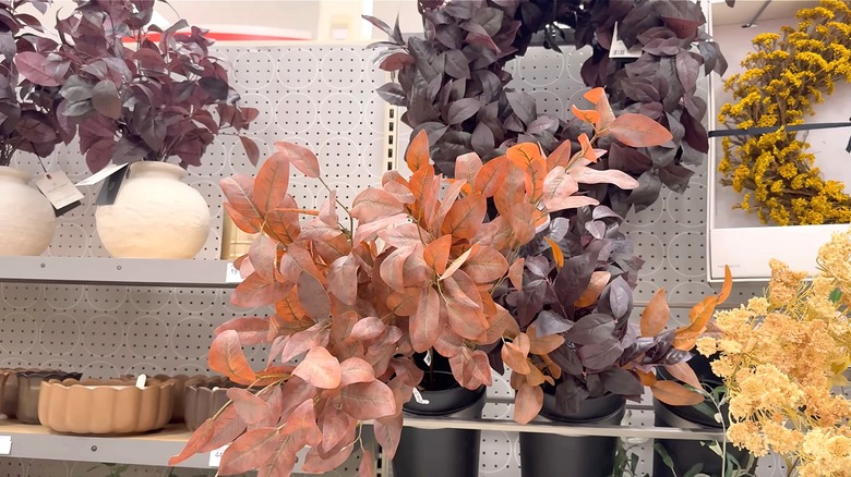 A display of fake orange and dark purple greenery in a store.