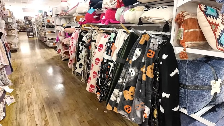 An assortment of blankets with Halloween themed prints displayed in a store.