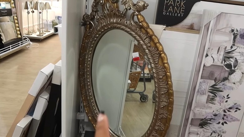 An ornate gold and grey mirror on display in a store.