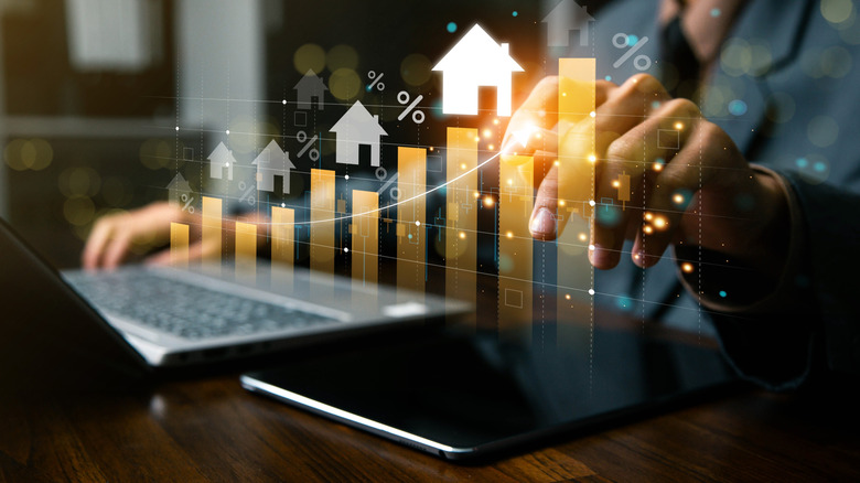 A businessperson analyses real estate investment data on a computer