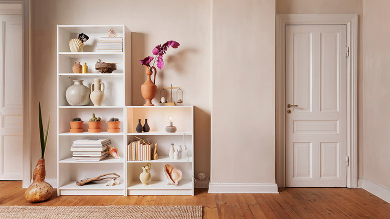 Decorative items are arranged on two white BILLY bookshelves from IKEA