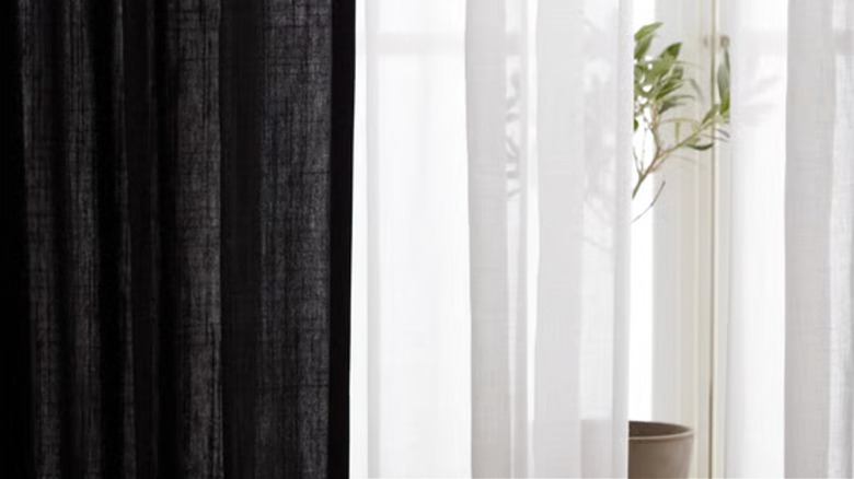 A gray RITVA curtain from IKEA hangs next to a white sheer