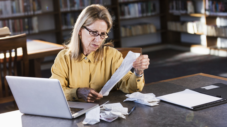 older woman checking receipts