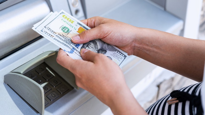 woman withdrawing american bills