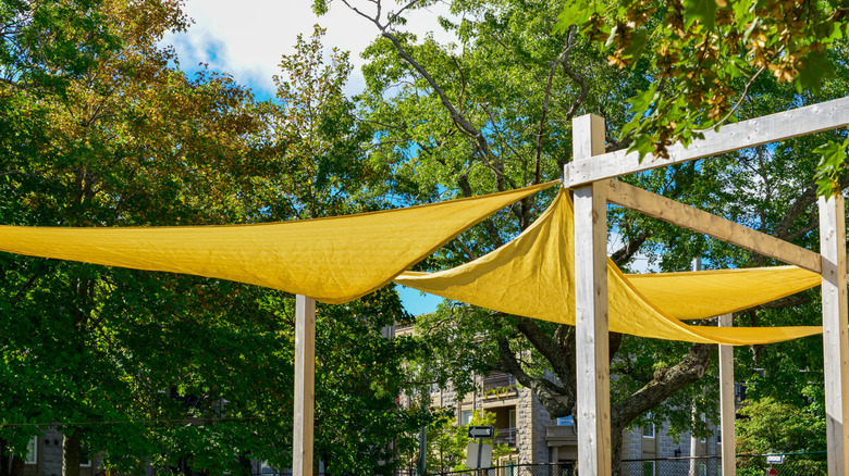 Old canvas drop cloths are spread out over the backyard to provide shade.
