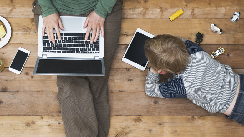 a mother and son using electronic devices on the floor