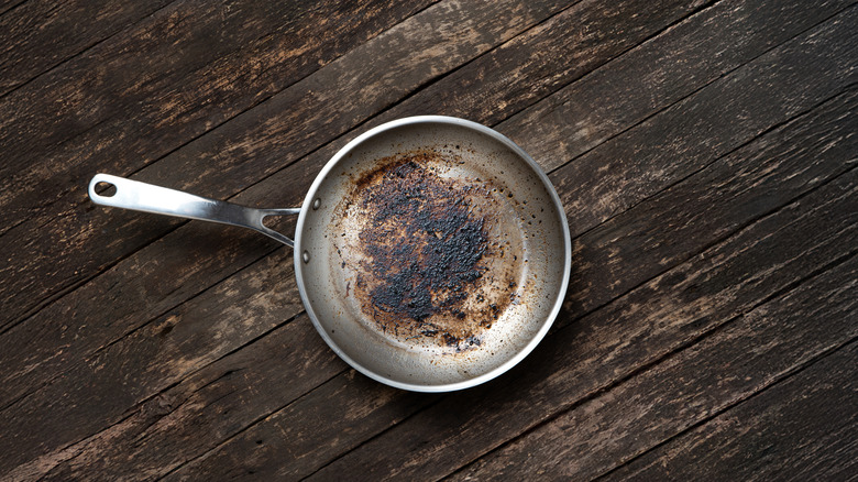 Close up of aluminum frying pan covered in burnt stains