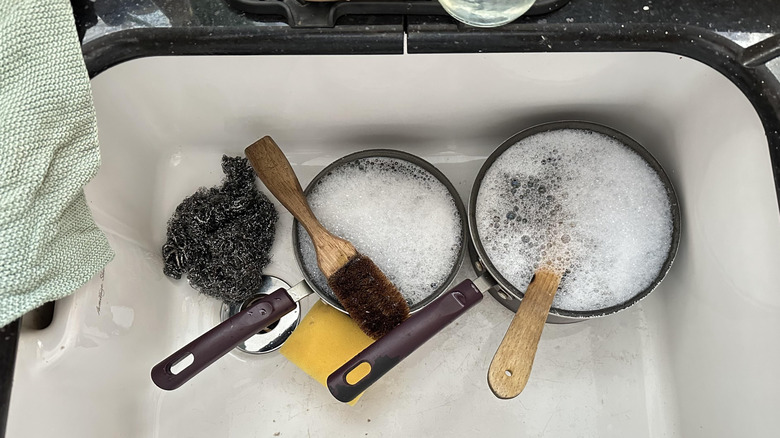 Close up of dishes soaking in sink