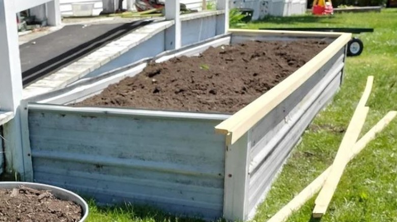 A raised garden bed made out of scrap roofing metal.