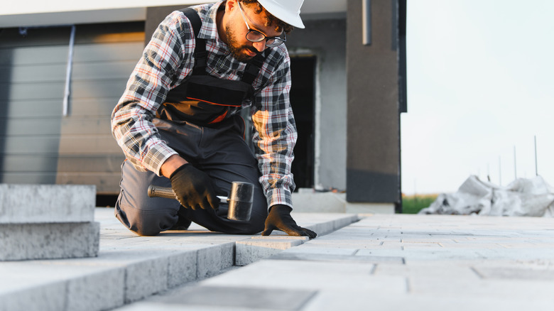Person installing permeable pavers into a driveway