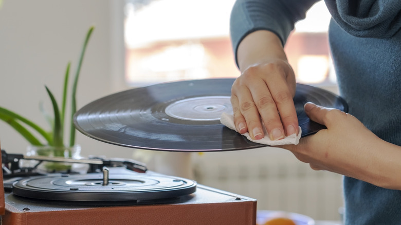 Someone wiping down a vinyl record.