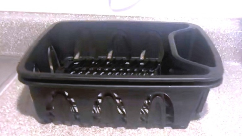 Black plastic dish drying rack sitting on a counter.
