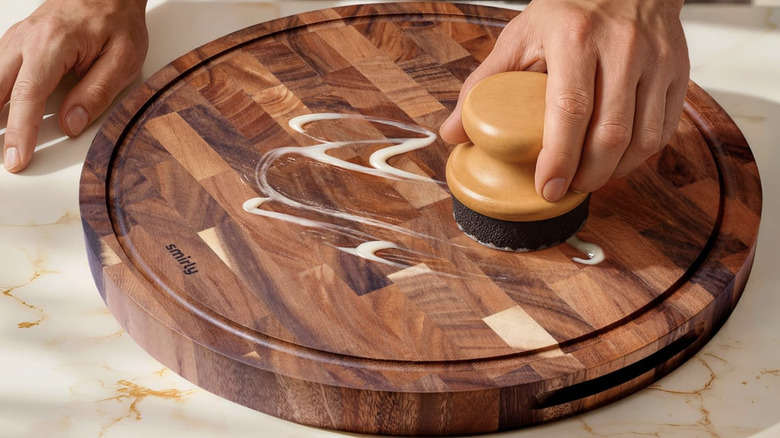 A person oiling a round end grain cutting board