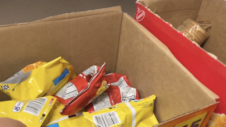 Cardboard boxes with lids removed and individual snacks inside.