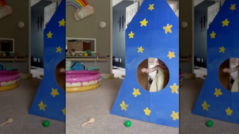 An old Costco cardboard box repurposed into a kids' play area.