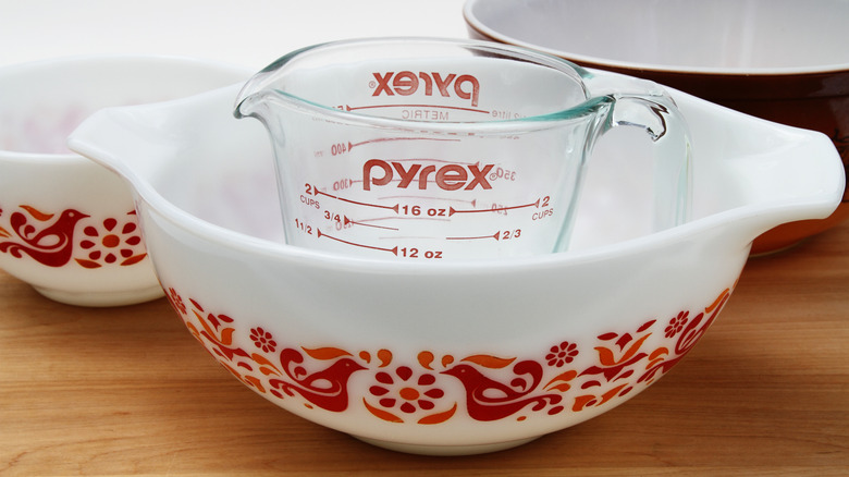 A pyrex measuring cup on top of a vintage pyrex bowl