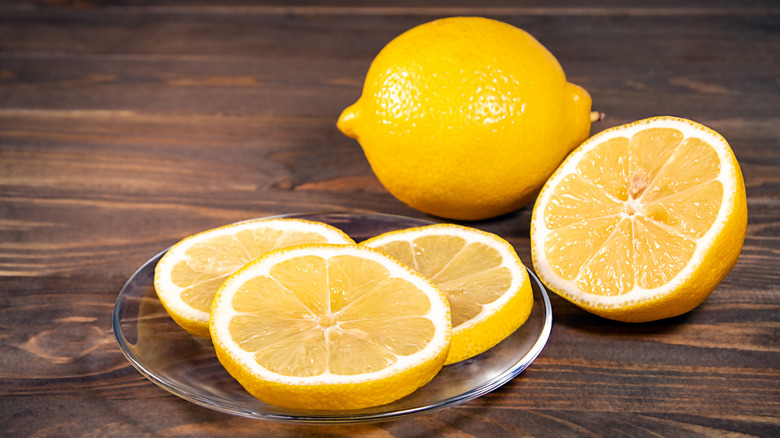 Close up of lemons and lemon slices on plate
