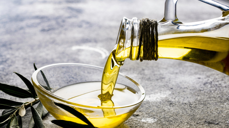 Close up of olive oil pouring into bowl