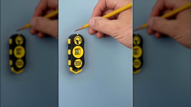 A man using C.H. Hanson's pocket-sized stud finder
