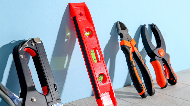 Various tools and gadgets lined up against a wall