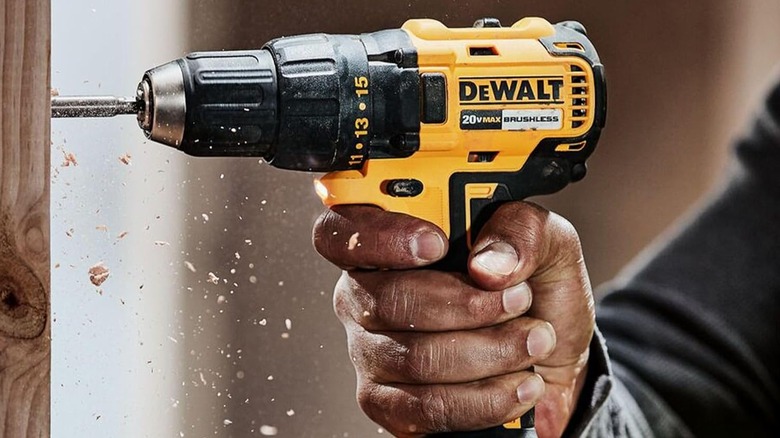 A DEWALT drill being used to drill a hole in wood