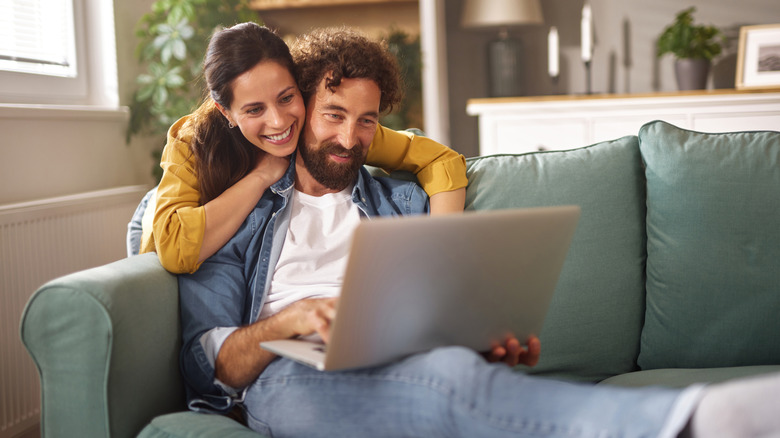 A man and woman using a computer in their home