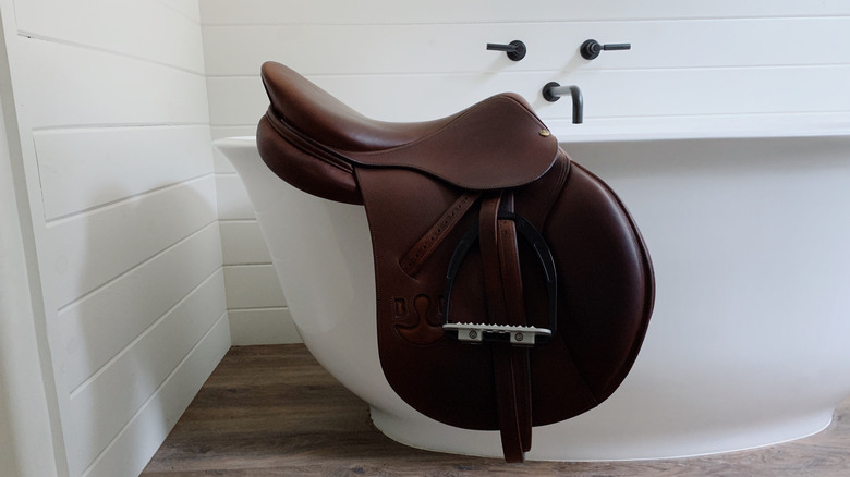 Equestrian gear on the edge of a bathtub
