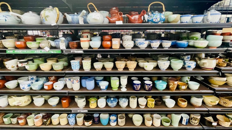 Assorted mugs on thrift store shelves