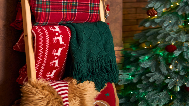 A plaid Christmas blanked on a wooden ladder.