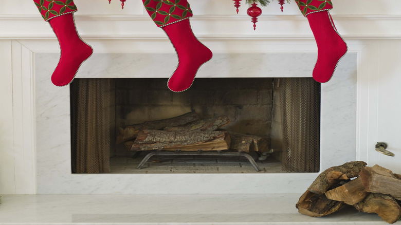 Matching red stockings hanging on a white fireplace.