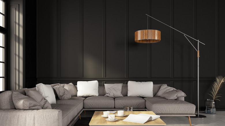 living room with black walls and gray couch