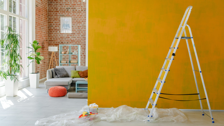 yellow wall with ladder in front of it in a brick wall loft