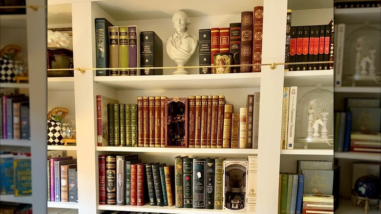 A bookshelf case with gallery rail on top shelf