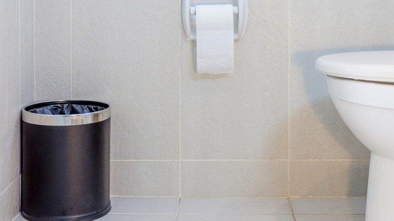 bathroom with black trash can