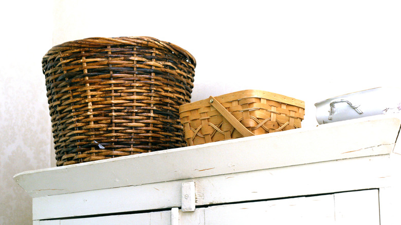 Woven baskets on top of kitchen cabinets