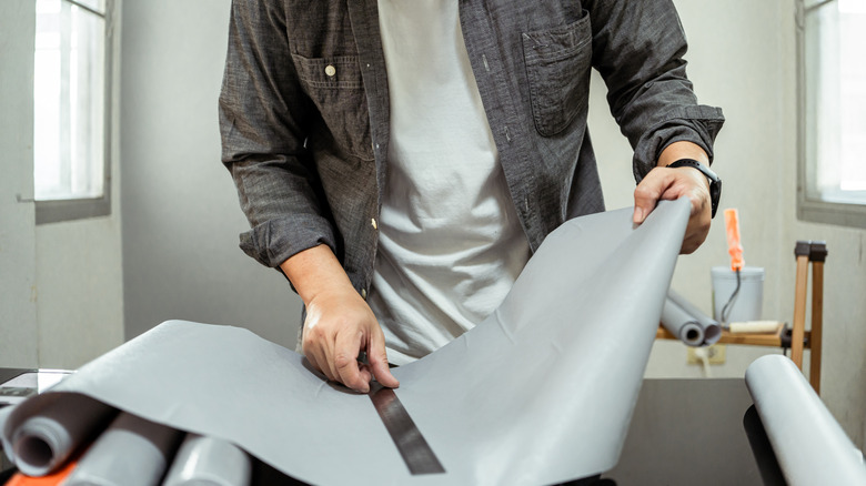 Man cutting vinyl adhesive sheet