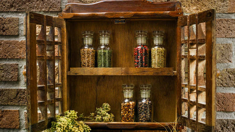 Wooden spice cabinet on a brick wall