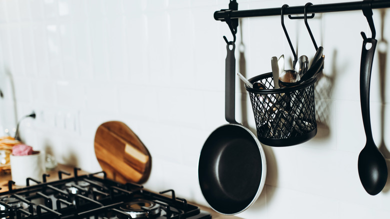 Kitchen rail over counter with pots and utensils hanging on it