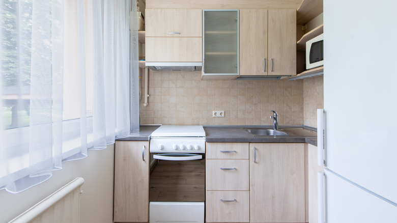Small apartment kitchen with simple finishes and a large window