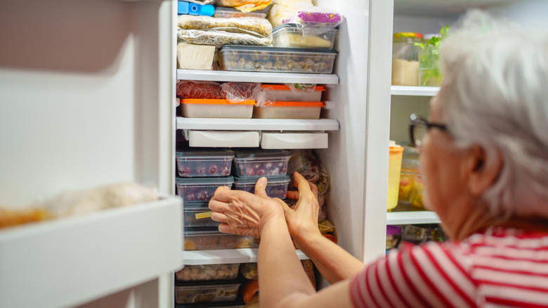 Woman placing neatly stacking storage containers in the freezer