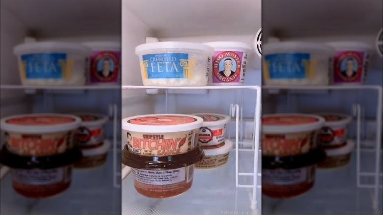 Metal storage shelf in freezer with food underneath and on top of it