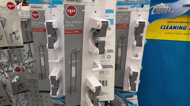 Rack of Dollar Tree mop and broom holders