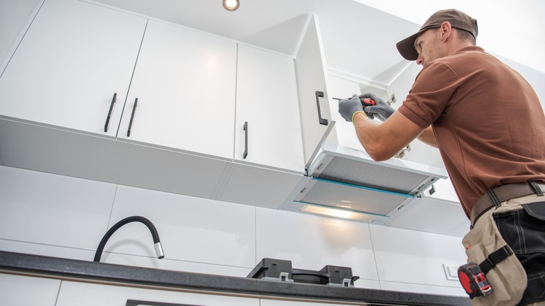 man installing kitchen cabinet