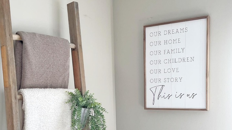 A blanket ladder in the corner of a room with blankets on each rung