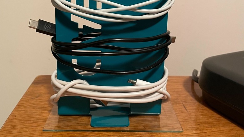 A metal bookend wrapped in three cords