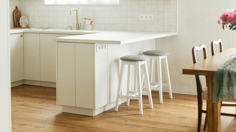 Kitchen with all-white walls, cabinets, countertops, and furniture