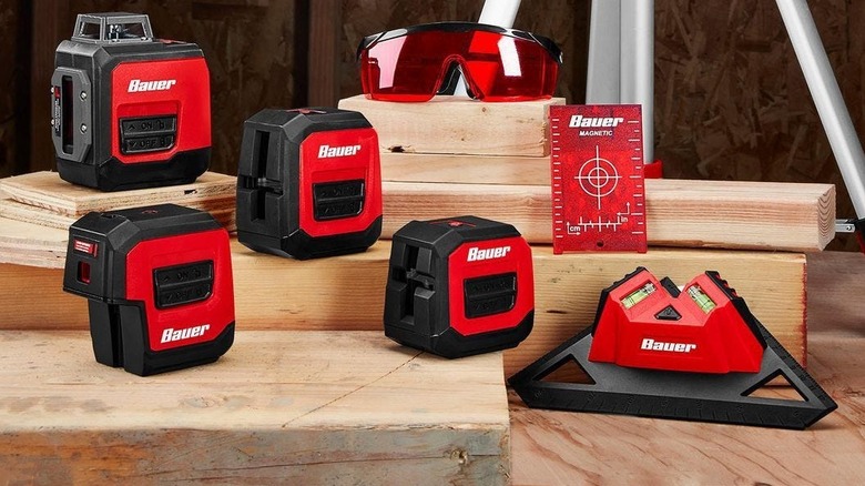 Selection of Bauer laser levels on a woodshop table